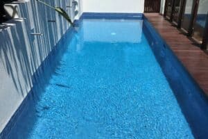 blue fully tiled pool with white wall
