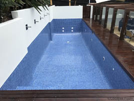 fully tiled pool in blue with white wall