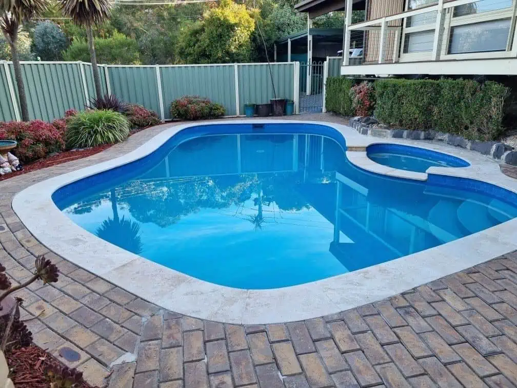 Full renovation, ivory travertine with CooWee Mid Blue waterline tile. Interior sky blue with dark blue speck and sparkle.