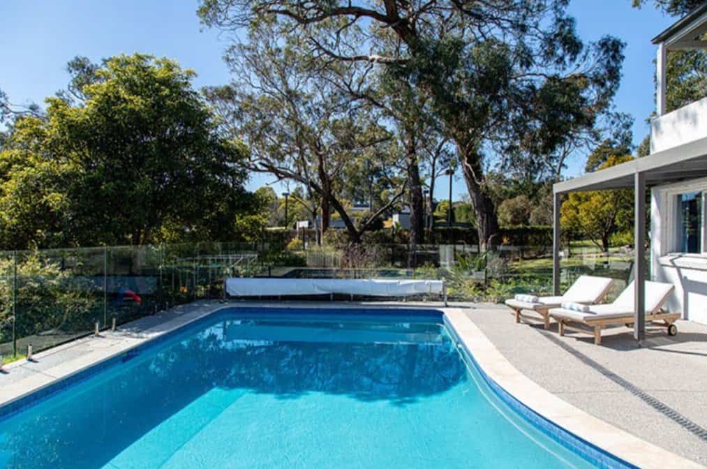 Full pool renovation with Ivory travertine, mid blue tiles and Coowee light blue interior. In Mount Eliza. After, professional picture for sale of house.